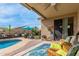 Covered patio with view of pool, adjacent yard and lounge seating at 10130 S 185Th Dr, Goodyear, AZ 85338