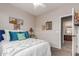 Cozy bedroom featuring a queen bed with white comforter and decorative pillows and ensuite bathroom at 10130 S 185Th Dr, Goodyear, AZ 85338
