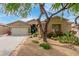 Charming single-story home with desert landscaping, a two car garage, and a beautiful tree at 10130 S 185Th Dr, Goodyear, AZ 85338