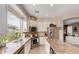 Bright kitchen features granite countertops, white cabinetry, stainless steel appliances, and a large window overlooking the yard at 10130 S 185Th Dr, Goodyear, AZ 85338