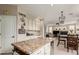 Granite island in the kitchen with views of an open floorplan leading to a living room at 10130 S 185Th Dr, Goodyear, AZ 85338