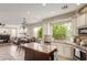Open kitchen with an island features stainless steel appliances and a view of the living room at 10130 S 185Th Dr, Goodyear, AZ 85338