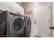 Modern laundry room with front load washer and dryer and overhead storage at 10130 S 185Th Dr, Goodyear, AZ 85338