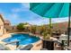 Backyard pool with patio seating, desert landscaping, and clear blue sky at 10130 S 185Th Dr, Goodyear, AZ 85338