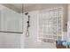 Elegant walk-in shower with a glass block window and a rainfall shower head for a luxurious spa-like experience at 10130 S 185Th Dr, Goodyear, AZ 85338
