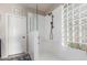 Walk-in shower featuring white marble walls, a glass partition, and a convenient shower bench at 10130 S 185Th Dr, Goodyear, AZ 85338
