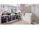 Well-lit bathroom showcasing dual sinks, granite counters, bathtub, and a glass-enclosed shower at 10909 W Frier Dr, Glendale, AZ 85307