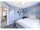 Serene bedroom featuring soft blue walls, comfortable bed, and a glimpse into another room at 10909 W Frier Dr, Glendale, AZ 85307
