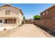 This driveway features a long concrete path between two homes leading to a wooden gate in the distance at 10909 W Frier Dr, Glendale, AZ 85307