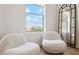 Bright sitting area with two cozy white chairs and a large window with a view at 14575 W Mountain View Blvd # 11308, Surprise, AZ 85374