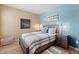 Bright bedroom with an accent wall, wood-look floors, and two end tables at 14950 W Mountain View Blvd # 7111, Surprise, AZ 85374