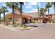 Community entrance with lush landscaping, arched entryway, and brick paving at 14950 W Mountain View Blvd # 7111, Surprise, AZ 85374