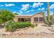 Exterior view of a home showcasing a covered patio, desert landscaping, and a natural desert yard at 15133 W Wildfire Dr, Surprise, AZ 85374
