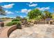 Beautiful backyard showcasing a stone waterfall feature, tiled patio, and lush desert landscaping at 15133 W Wildfire Dr, Surprise, AZ 85374