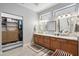 Bathroom with double sinks, framed mirrors, wood cabinets and walk-in closet at 15133 W Wildfire Dr, Surprise, AZ 85374