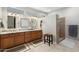 Bathroom featuring double sinks, a granite countertop, tan tile, and a walk-in shower at 15133 W Wildfire Dr, Surprise, AZ 85374