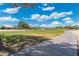 Picturesque view of the golf course with lush green grass and mature trees next to sidewalk at 15133 W Wildfire Dr, Surprise, AZ 85374