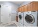 Spacious laundry room featuring side-by-side washer and dryer with storage cabinets at 15133 W Wildfire Dr, Surprise, AZ 85374