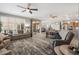 Bright living room with plush seating, neutral colors, and abundant natural light with view to dining and kitchen at 15133 W Wildfire Dr, Surprise, AZ 85374