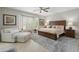 Inviting main bedroom with a bay window, plush seating, a wooden bed frame, and soft decor at 15133 W Wildfire Dr, Surprise, AZ 85374