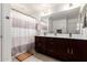 Well-lit bathroom features a double sink vanity with a large mirror and shower with curtain at 15423 N 22Nd Dr, Phoenix, AZ 85023