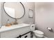 Modern half-bathroom with white vanity, gold fixtures, round mirror, and toilet at 15423 N 22Nd Dr, Phoenix, AZ 85023