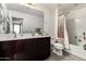 Bathroom featuring a well-lit sink with counter space, toilet and shower with tile surround at 15423 N 22Nd Dr, Phoenix, AZ 85023