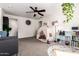 Bright, carpeted bedroom includes a play tent, ceiling fan, sitting area, and storage shelves at 15423 N 22Nd Dr, Phoenix, AZ 85023