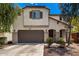 Attractive two-story home with a neutral stucco exterior, brown accents, and manicured landscaping at 15423 N 22Nd Dr, Phoenix, AZ 85023