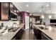 Modern kitchen with granite countertops, stainless steel appliances, dark cabinets, and wood flooring at 15423 N 22Nd Dr, Phoenix, AZ 85023