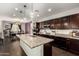 Spacious kitchen featuring an island with granite countertops, dark cabinets, and pendant lighting at 15423 N 22Nd Dr, Phoenix, AZ 85023