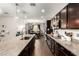 Spacious kitchen featuring an island with granite countertops, dark cabinets, and stainless steel appliances at 15423 N 22Nd Dr, Phoenix, AZ 85023