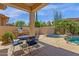 Covered patio with a table and chairs overlooking an outdoor grill, pool, and spa at 15608 E Chaparral Way, Fountain Hills, AZ 85268