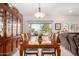 Dining area featuring a well-lit chandelier, a dining table set for eight, and backyard views at 15691 W Arbor Trl, Surprise, AZ 85374