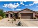 Charming single-story home showcasing desert landscaping, a tile roof and two-car garage at 15691 W Arbor Trl, Surprise, AZ 85374
