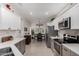 Open concept kitchen with stainless steel appliances, white cabinets, and dining area at 15691 W Arbor Trl, Surprise, AZ 85374