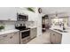 Kitchen with stainless steel appliances, white cabinets, and tile backsplash at 15691 W Arbor Trl, Surprise, AZ 85374