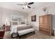 Bright bedroom featuring a ceiling fan, natural light, and wood furniture at 15691 W Arbor Trl, Surprise, AZ 85374