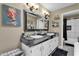 Stylish bathroom with dual sinks, black countertops, decorative mirror and black and white backsplash at 15834 E Sunflower Dr # 2, Fountain Hills, AZ 85268