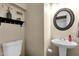 Clean powder room with pedestal sink, round mirror, and neutral walls at 15834 E Sunflower Dr # 2, Fountain Hills, AZ 85268