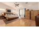 Spacious bedroom with vaulted ceilings, neutral walls, wood floors, a ceiling fan, and a large window at 16448 W Tether Trl, Surprise, AZ 85387