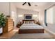 Bright bedroom featuring vaulted ceilings, a ceiling fan, wood floors, and a neutral color palette at 16448 W Tether Trl, Surprise, AZ 85387