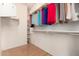 Walk-in closet featuring wood floors, neutral walls, and closet rods with shelves for ample storage at 16448 W Tether Trl, Surprise, AZ 85387