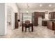 Dining room with tile floors, dark wooden furniture, a window, and brown kitchen cabinets at 16448 W Tether Trl, Surprise, AZ 85387