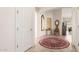 Spacious foyer with tile floor, vintage rug, antique clock, mirror and table, and white walls at 16448 W Tether Trl, Surprise, AZ 85387
