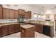 Gourmet kitchen featuring granite counters, stainless steel appliances, tile backsplash, and center island for entertaining at 16448 W Tether Trl, Surprise, AZ 85387