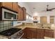 Kitchen with a range, blue tile backsplash, and granite countertops; view into the living room at 16448 W Tether Trl, Surprise, AZ 85387