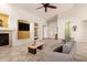 Open living room with a fireplace, a large TV, high ceilings, tile floors, and neutral colors at 16448 W Tether Trl, Surprise, AZ 85387