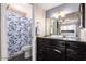 Well-lit bathroom featuring dark cabinetry, a vessel sink, and a shower/tub combination with a stylish shower curtain at 16814 N 31St Ave, Phoenix, AZ 85053