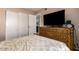 This bedroom boasts a large dresser, television, closet, and doorway to the en suite bathroom at 16814 N 31St Ave, Phoenix, AZ 85053